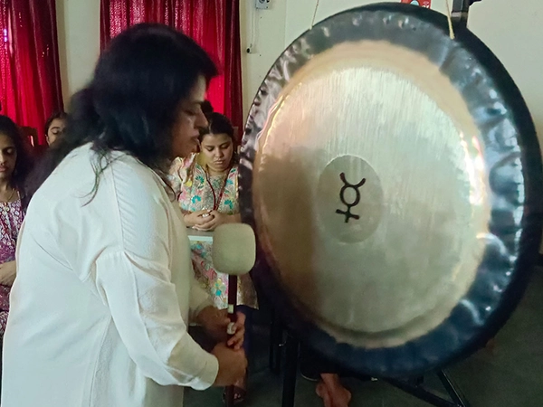 Facilitator leads sound healing gong session for student relaxation at University of Madras Campus.