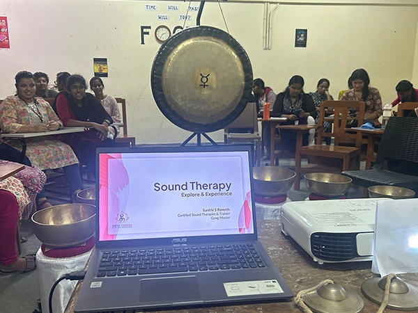 Students attending a sound therapy session with gong and bowls at University of Madras classroom