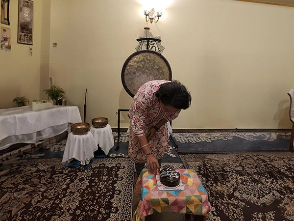 A joyful birthday cake moment during Santhoshi’s healing celebration, filled with love and energy.