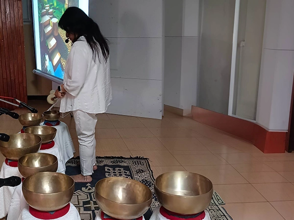 Sound healing bowl demonstration for students in India to explore therapeutic sound vibrations.