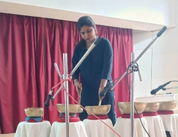 Demonstration and hands-on practice of sound healing therapy during a college wellness event.