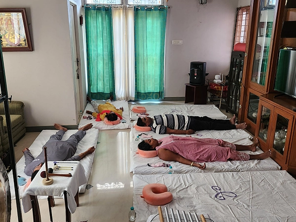 Trainers conduct sound therapy using bowls and gongs to promote mental and physical wellness.
